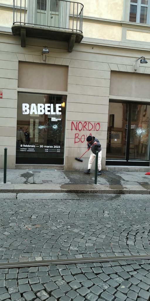 Man cleaning damage after anarchists' protest in Turin, Italy, March 4, 2023, outside of Babele art gallery on Via Consolata, across from the Consolata church. Graffiti in red says "Nordio boia," or "Nordio the Executioner," a reference to the Minister of Justice