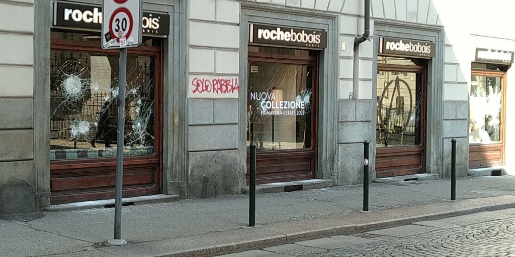 Broken storefront windows and graffiti saying "solo rabbia" or "only rage" on the Roche Bobois furniture showroom on Via Consolata the morning after the anarchists' protest on March 4, 2023