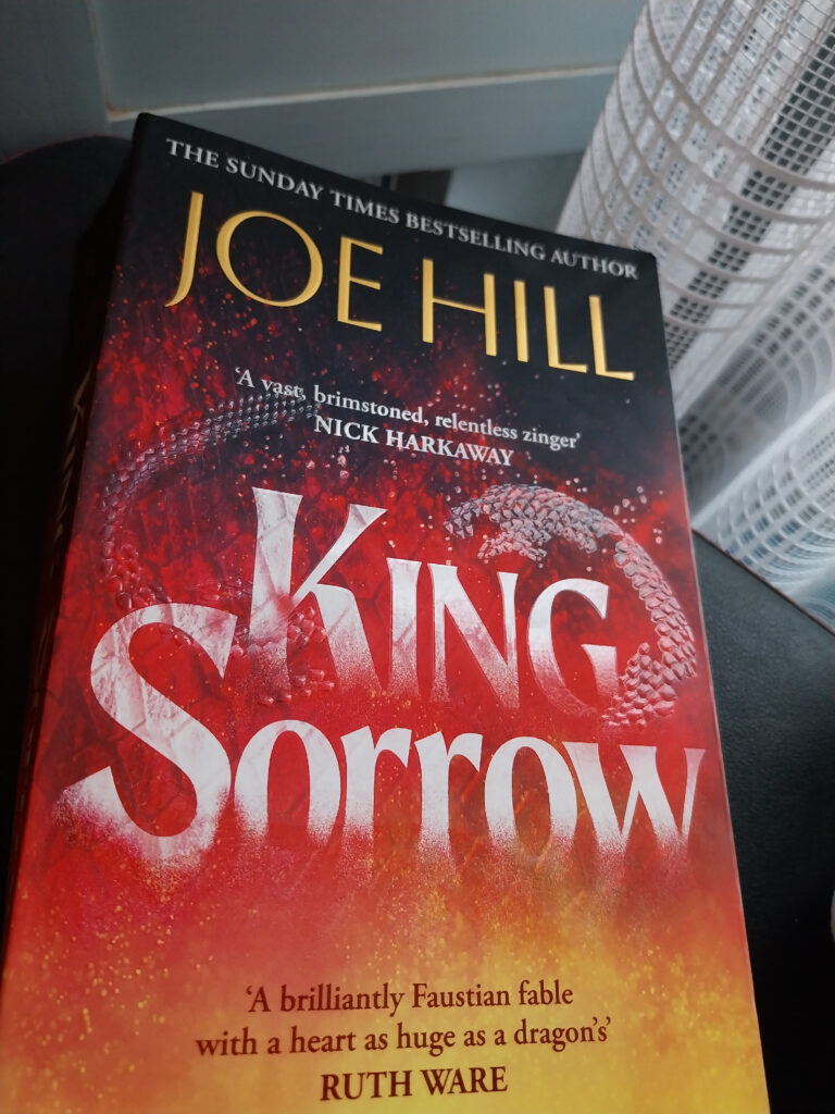 Photograph of King Sorry by Joe Hill showing red and orange UK cover with embossed dragon on the front. One of my twelve books of Christmas.