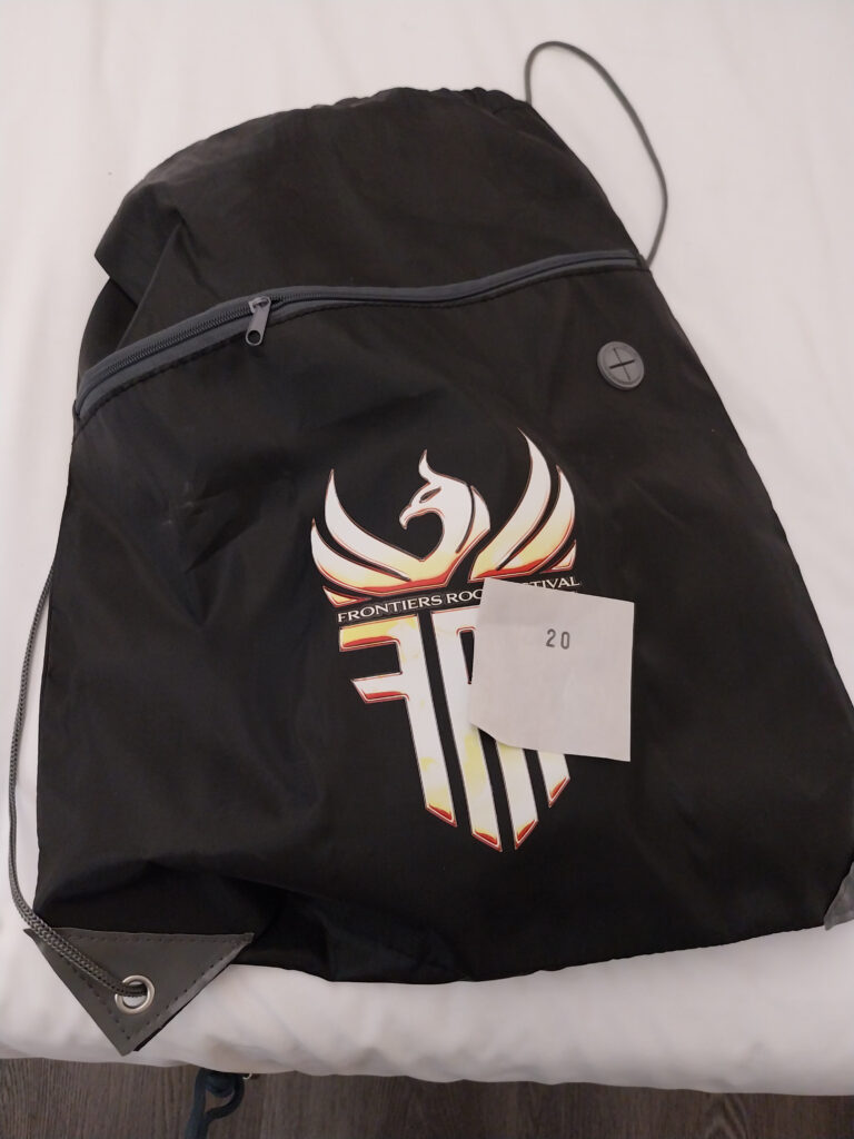 Photo of Frontiers Rock Festival 2026 backpack with winning raffle ticket with the number 20 on it